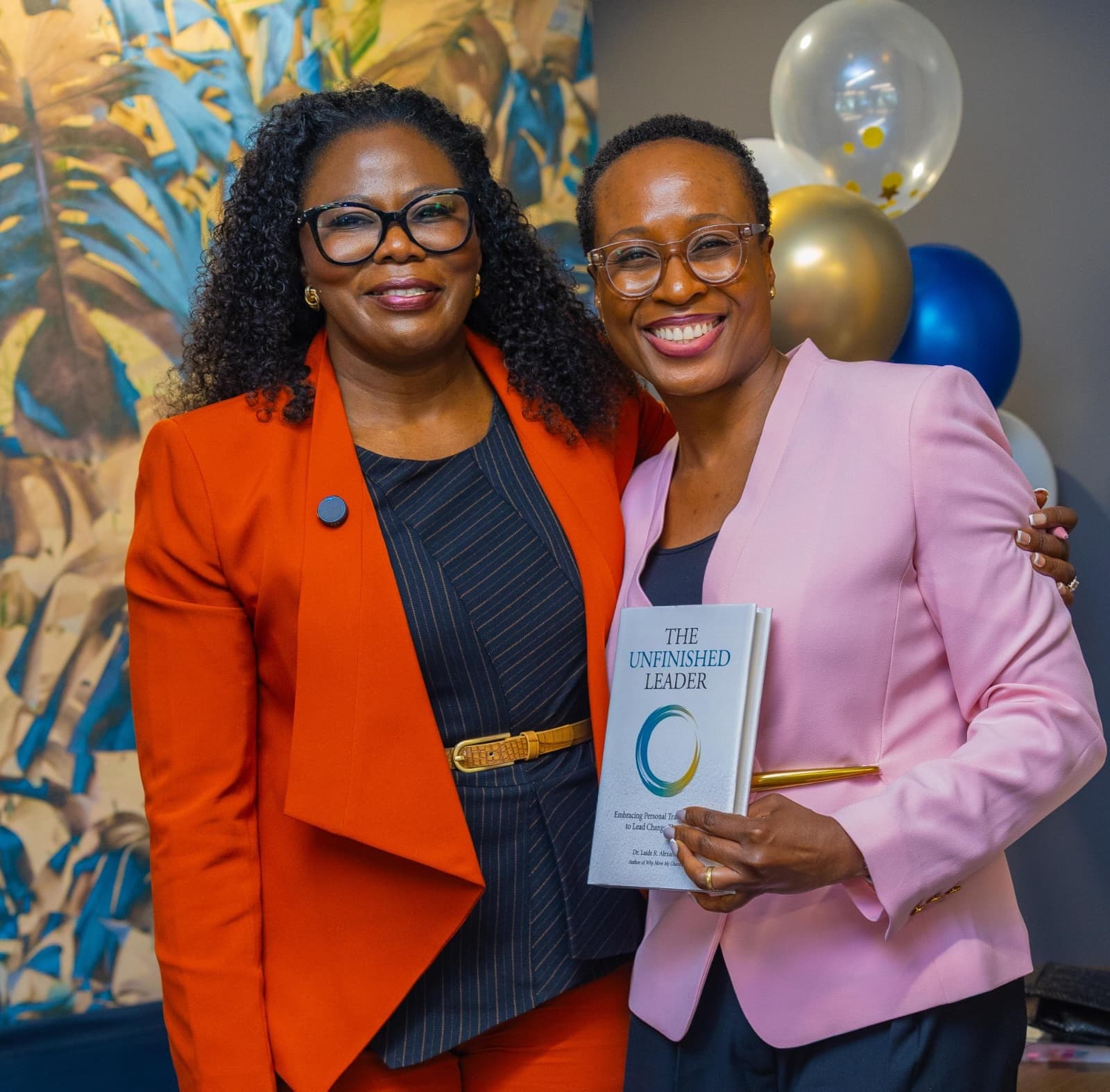 Dr. Laide Alexander with a reader holding The Unfinished Leader