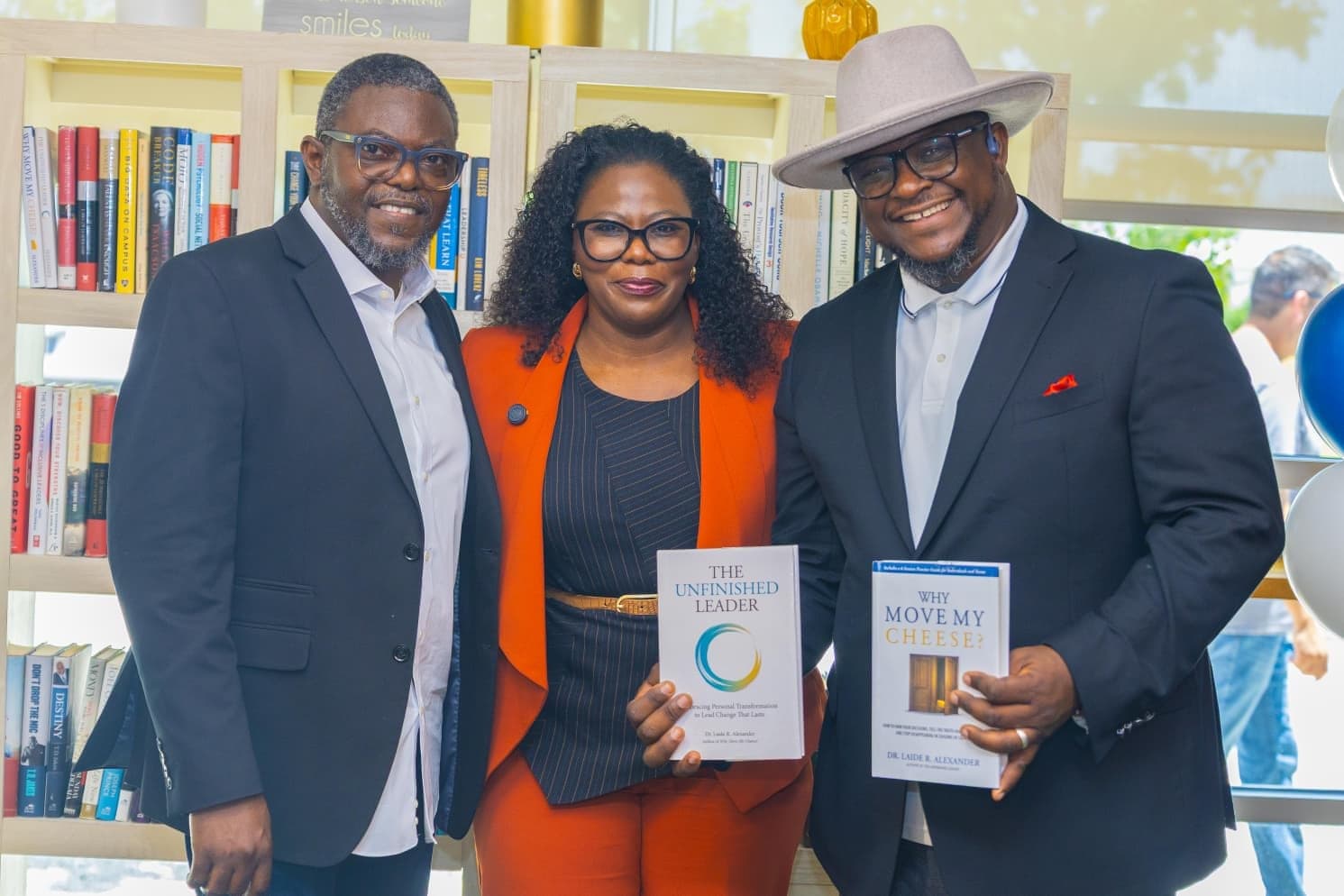 Dr. Laide Alexander with two guests holding her books