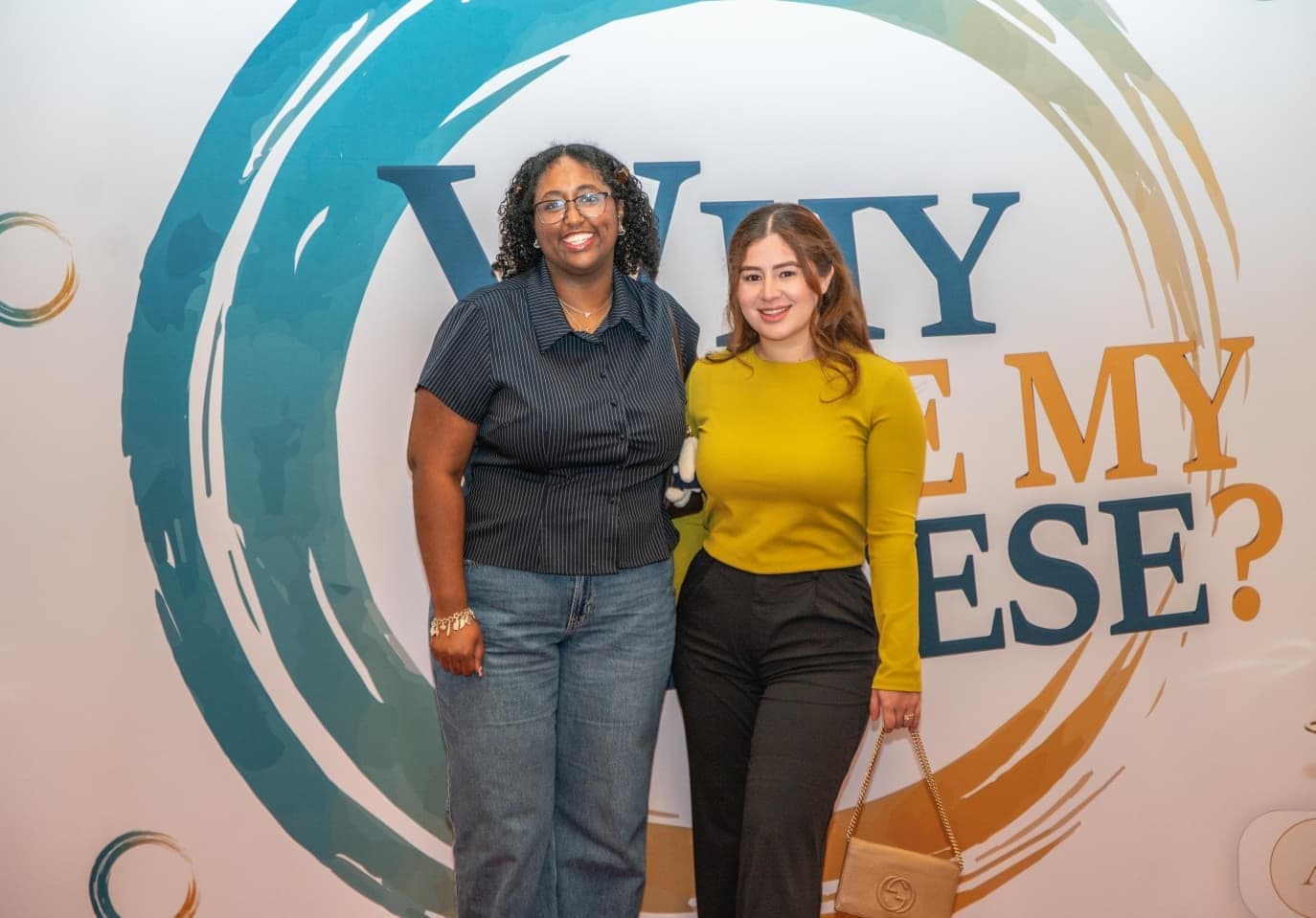 Two attendees at the conference backdrop