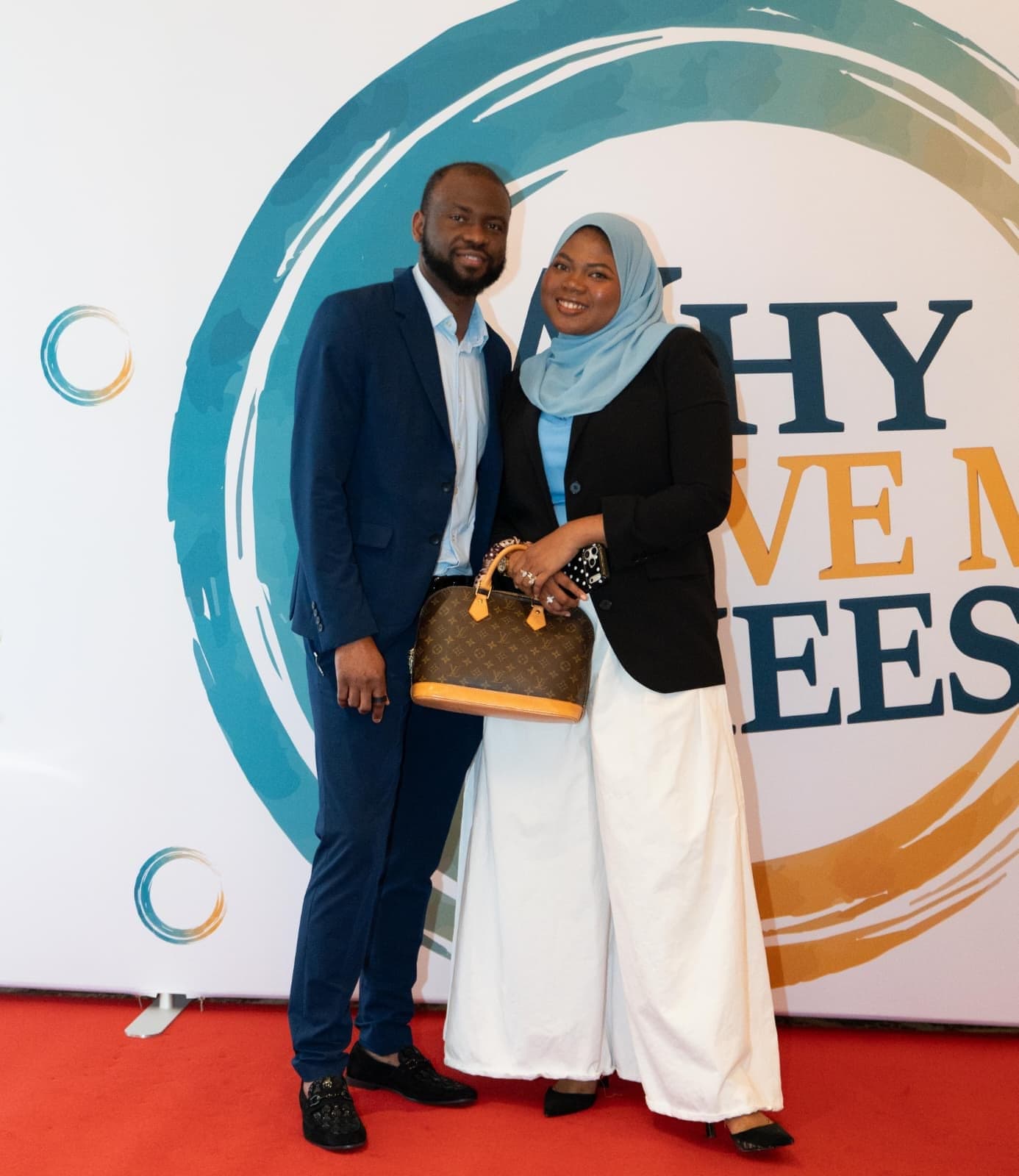 Two attendees at the conference backdrop